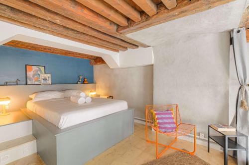 une chambre avec un lit et une chaise dans l'établissement Cosy et Atypique Hôtel de Ville et quais du Rhône, à Lyon