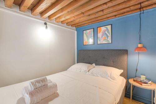 - une chambre avec un lit blanc et un mur bleu dans l'établissement Cosy et Charmant Hôtel de Ville et quais du Rhône, à Lyon