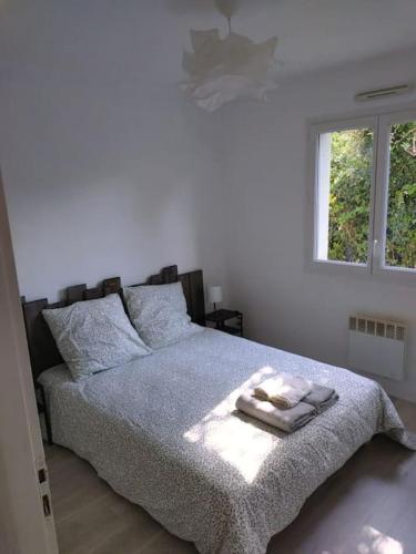 une chambre avec un lit avec une couverture et une fenêtre dans l'établissement Maison 4 chambres, à Eysines