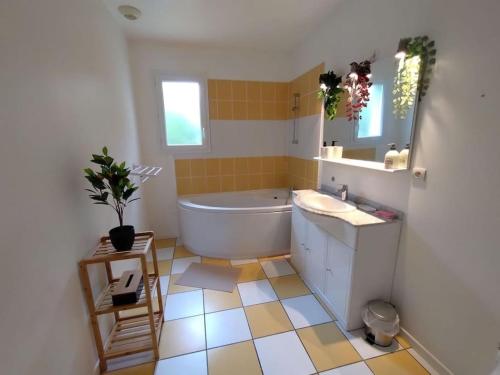 a bathroom with a tub and a sink and a mirror at Maison 4 chambres in Eysines