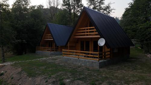 a large wooden cabin with a black roof at Ethno Village Long Story in Kolašin