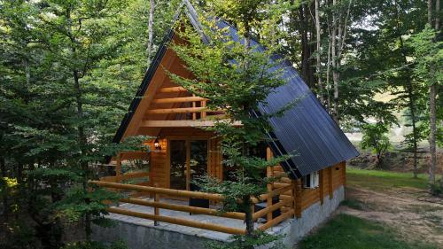 a cabin in the woods with a blue roof at Ethno Village Long Story in Kolašin