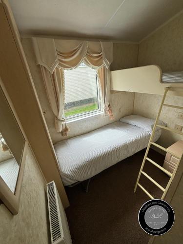 a small room with a bunk bed and a window at Parkside 41 - Located on Butlins Skegness Caravan Village, WiFi - Meadow Lakes Caravan & Lodge Hire in Lincolnshire