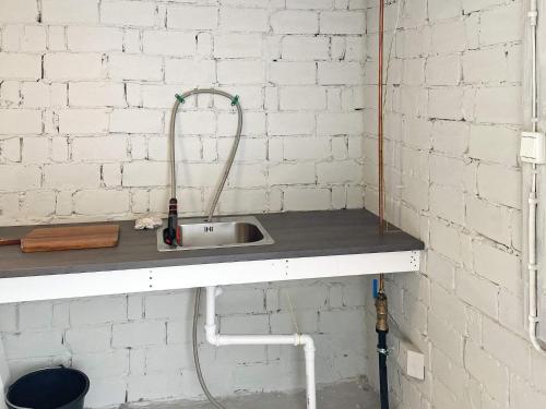 a sink in a room with a white brick wall at 6 person holiday home in BØMLO in Bømlo