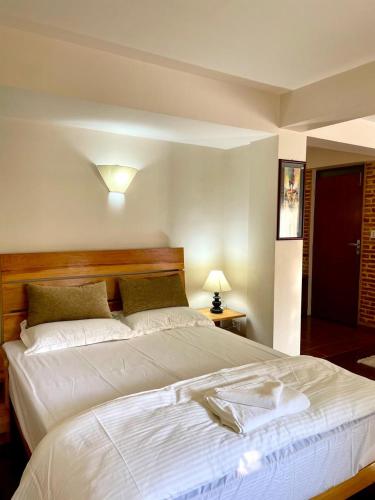 Una gran cama blanca en una habitación con una lámpara. en Chiba Homes, en Pātan