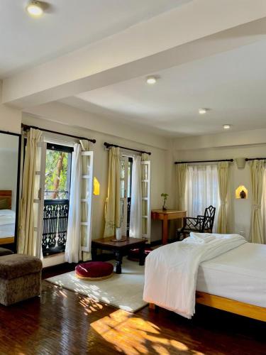 Un dormitorio con una cama blanca grande y un escritorio en Chiba Homes, en Pātan