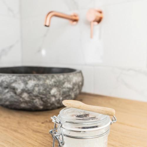 a glass jar on a counter with a sink at Op Oost Boutique hotel & Restaurant het Kook Atelier in Oosterend