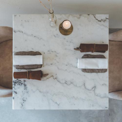 a white marble table with a candle on it at Op Oost Boutique hotel & Restaurant het Kook Atelier in Oosterend