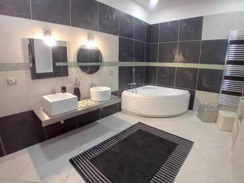 a bathroom with a tub and a sink and a mirror at Casa vacanze Emma Siracusa Canicattini Bagni in Canicattini Bagni