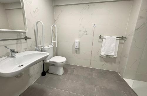 a white bathroom with a sink and a toilet at Barakaldo Rooms in Barakaldo