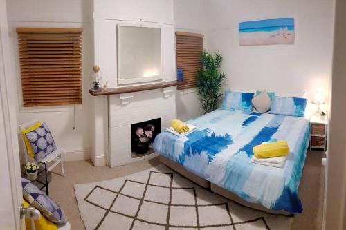 a bedroom with a large bed and a fireplace at Homely Beachfront Apartment with Direct Beach Access - The Coachhouse in Narrabeen