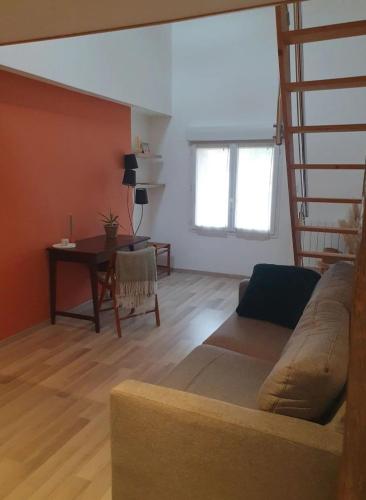un salon avec un canapé, une table et une fenêtre dans l'établissement Chambre chez l'habitant avec petit déjeuner à 5 mins du Futuroscope, à Chasseneuil-du-Poitou