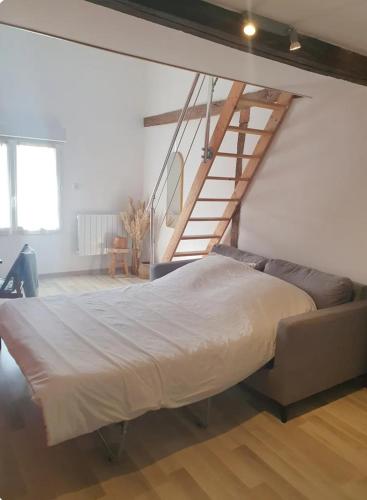 Cette chambre comprend un grand lit et un escalier. dans l'établissement Chambre chez l'habitant avec petit déjeuner à 5 mins du Futuroscope, à Chasseneuil-du-Poitou