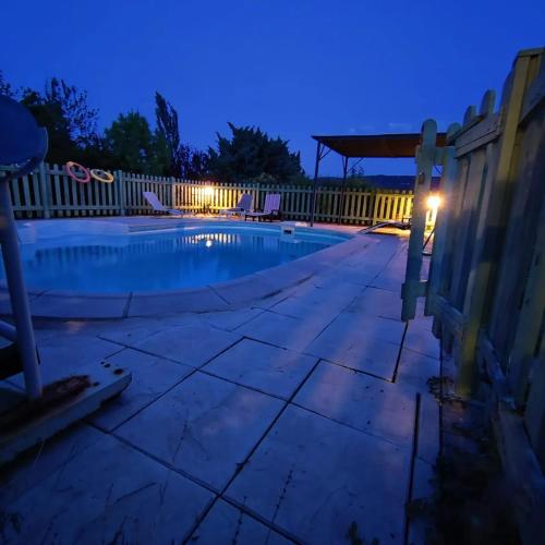an empty swimming pool at night at Maison paisible à Veyras avec piscine privée et vue montagne in Veyras