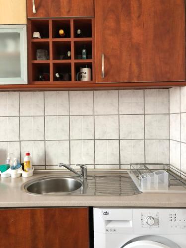 a kitchen counter with a sink and a dishwasher at House For Stay in Pristina