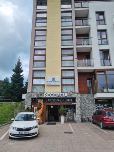 a white car parked in front of a building at Apartmán Crocus 415 in Štrbské Pleso