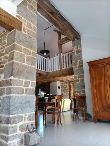une cuisine et une salle à manger avec un mur en pierre dans l'établissement La Rezendine, à Saint-Georges-de-Reintembault