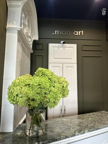 a vase of flowers on a counter with a door at Готель-бутік на Кобилянській MonArt by Willox in Chernivtsi