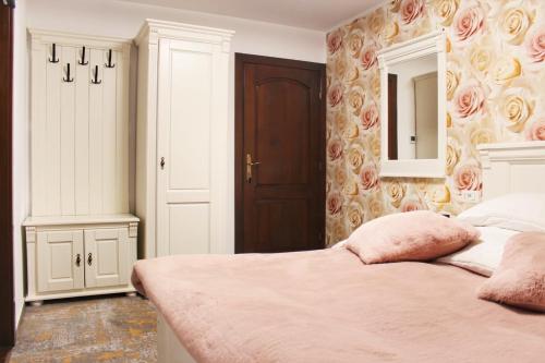 a bedroom with a bed and a mirror and a door at Pensiunea AlexOlar New One in Horea