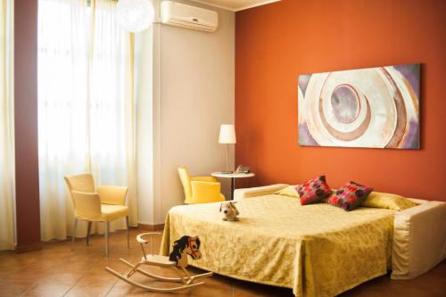 a bedroom with a bed with an orange wall at Lizard Hotel in Como