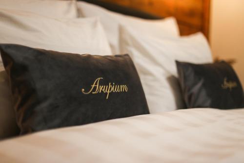 a bed with black and white pillows on it at House Arupium - HOT TUB in Otočac