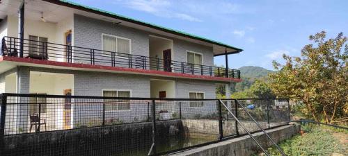 un edificio con una valla delante en The Nest Farmstay, en Paror