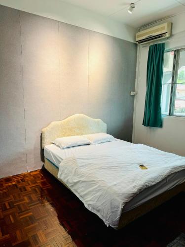 a bed in a room with a green curtain at HM AIRBNB in Sibu