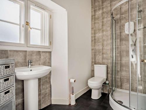 a bathroom with a sink and a toilet and a shower at North Lodge Retreat Allonby in Maryport