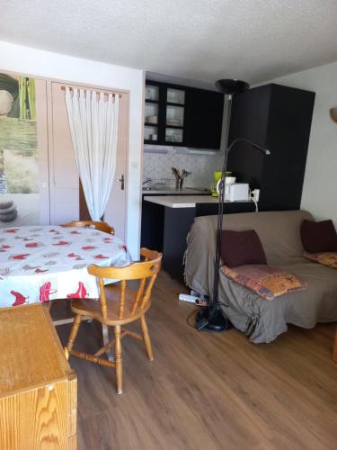 Cette chambre comprend un lit, un canapé et une table. dans l'établissement Studio Cabine Pied de Piste La Mongie, à Bagnères-de-Bigorre