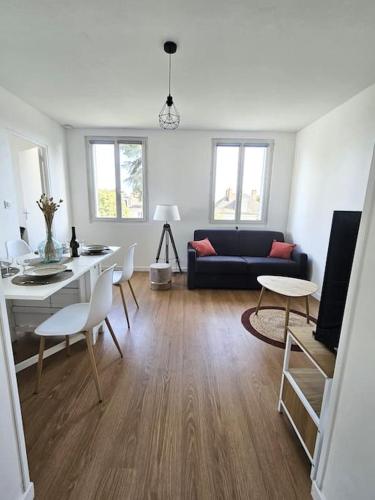 un salon avec un canapé, une table et des chaises dans l'établissement Superbe appartement rénové, à Bourges