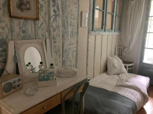 a room with a table with a mirror and a bed at La Vigne in La Neuveville