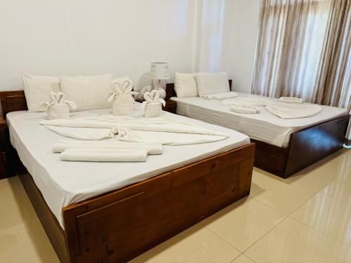 two beds in a room with towels on them at Gamodh Citadel Resort in Anuradhapura