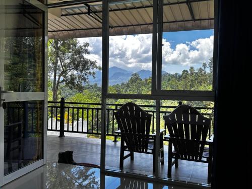 two chairs sitting on a porch with a view at Viyanga Homestay in Ella