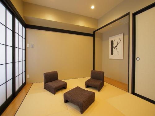 two chairs in a waiting room with yellow walls at Hotel Regina Kawaguchiko in Fujikawaguchiko