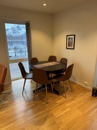a dining room with a table and chairs and a window at Nappstraumen Seafront Cabin, Lilleeid 68 in Gravdal