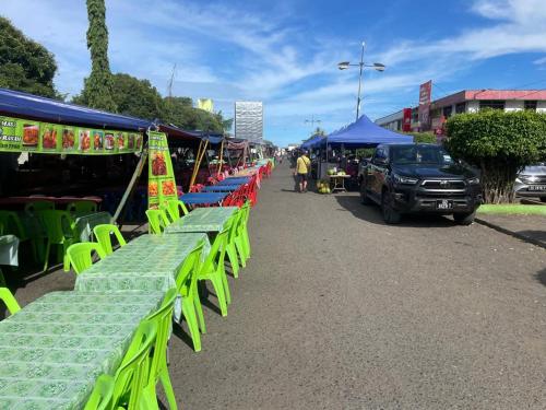a group of green tables and chairs at a market at Tabin Lodge Budget Stay in Lahad Datu