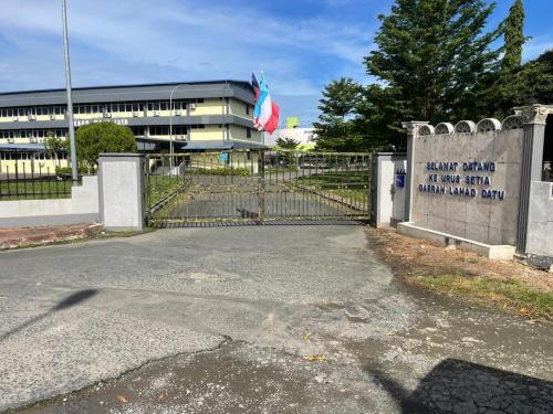 a gate in front of a building with a building at Tabin Lodge Budget Stay in Lahad Datu