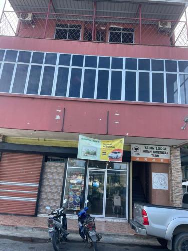 two motorcycles parked in front of a building at Tabin Lodge Budget Stay in Lahad Datu