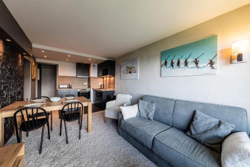 un salon avec un canapé et une table dans l'établissement L Ourson - Immodreams - Avoriaz, à Avoriaz
