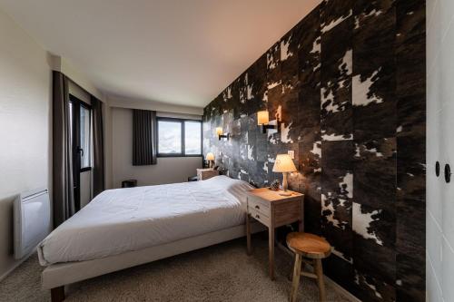 une chambre avec un lit et un mur en bois dans l'établissement L Ourson - Immodreams - Avoriaz, à Avoriaz