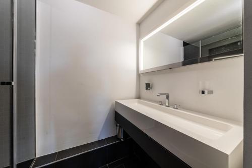 une salle de bain avec un lavabo et un miroir dans l'établissement L Ourson - Immodreams - Avoriaz, à Avoriaz