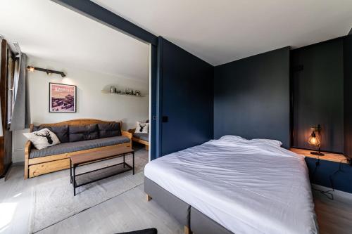 une chambre avec un grand lit et un canapé dans l'établissement Le Half-Pipe - Immodreams - Avoriaz, à Avoriaz