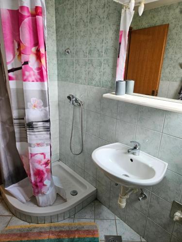 a bathroom with a sink and a shower curtain at Apartmani Maria in Preko
