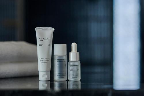 a group of three bottles of moisturizers sitting on a table at The Royal Park Hotel Iconic Nagoya in Nagoya