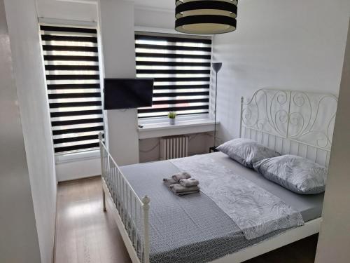 a bedroom with a white bed with a teddy bear on it at WHITE CITY 2 in Belgrade