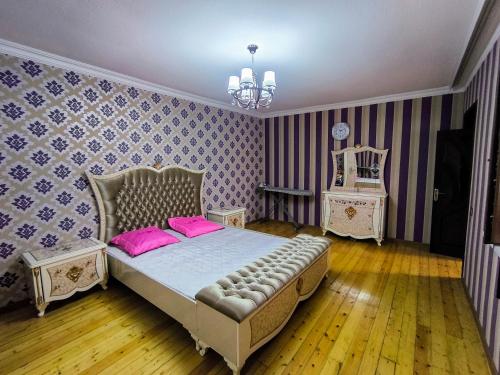 a bedroom with a bed with pink pillows and a mirror at Green Home in Gabala
