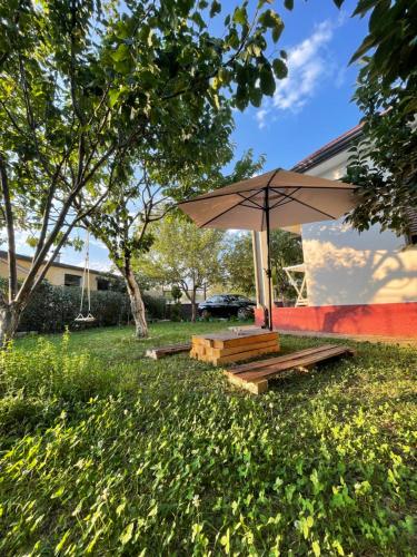 a picnic table with an umbrella in a yard at Riza Guest House in Pukë