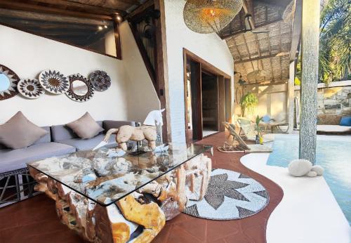 a living room with a couch and a glass table at Kaleydo Villas in Gili Trawangan