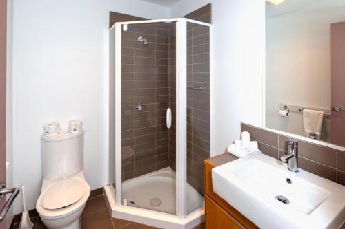a bathroom with a shower and a toilet and a sink at Central Hotel Hobart in Hobart