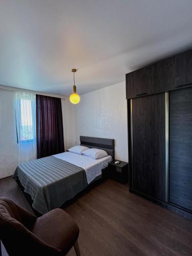a bedroom with a bed and a chair in it at Villa Harmony in Chakvi